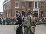Verklede mensen praten op kerkplein bij Living History Appingedam. De vrouw lacht.