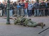 Verklede soldaat light op de grond op kerkplein bij Living History Appingedam.