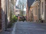 Oude auto rijdt door een straat bij Living History Appingedam.