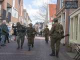 Verklede soldaten lopen door straat bij Living History Appingedam.