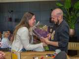 Lachende man en vrouw met bos bloemen.