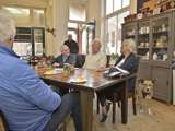 Mensen aan tafel bij koffiebar 't Stroopwafeltje, ook is een hond aanwezig.