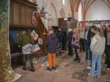 Mensen staan in de kerk en bekijken de kunstwerken.