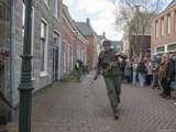 Verklede soldaat rent door straat bij Living History Appingedam.