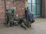 Verklede soldaten liggen tegen de kerk aan bij Living History, Appingedam.