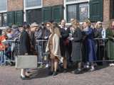 Verklede mensen met koffers op kerkplein bij Living History Appingedam.