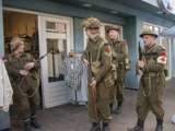 Verklede soldaten staan bij winkel in de dijkstraat bij Living History Appingedam.