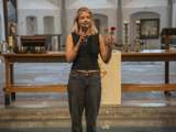 Vrouw spreekt in microfoon in de kerk.