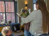 Vrouw overhandigt boeket bloemen bij de Pelikaan-uitreiking.