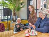 Vier vrouwen praten en glimlachen bij de Pelikaan-uitreiking.