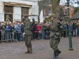 Verklede soldaten op kerkplein bij Living History, Appingedam, houden geweren in de lucht.