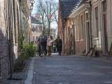 Verklede mensen rennen door straat bij Living History Appingedam.