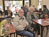 Jan Dijkhuizen met camera op schoot bij koffiebar 't Stroopwafeltje.
