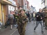 Verklede soldaten rennen door de straat heen bij Living History Appingedam.