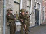 Verklede soldaten staan tegen muur aan bij Living History Appingedam.