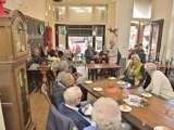 Grote groep mensen aan tafel bij koffiebar 't Stroopwafeltje.