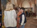 Mensen staan in de kerk bij de kunst tentoonstelling.