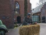 Verklede soldaat verstopt achter hooibaal op kerkplein bij Living History Appingedam.
