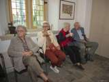 Drie vrouwen en een man zitten op stoelen.