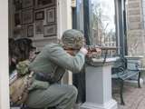 Verklede soldaat schiet vanuit deuropening bij Living History Appingedam.
