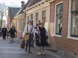 Verklede mensen lopen op straat bij Living History Appingedam.