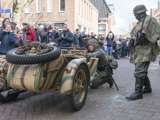 Verklede soldaat verstopt zich achter oude oorlogsmotor bij Living History Appingedam.
