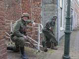 Verklede soldaten op brug, één glimlacht bij Living History Appingedam.