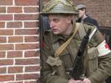 Verklede soldaat kijkt om de hoek van de kerk bij Living History Appingedam.
