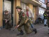 Verklede soldaat bukt met geweer bij Living History Appingedam.