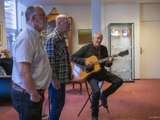 Drie mannen, één speelt gitaar op podium bij Damster Proza en Poëziefestival.