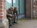 Verklede soldaten verstoppen zich achter de kerk bij Living History Appingedam.