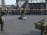 Verklede soldaten spelen toneelstuk op kerkplein waar ze een man neerschieten bij Living History Appingedam.