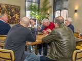 Mensen zitten gezellig met koffie bij de Pelikaan-uitreiking.