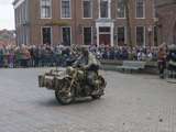 Verklede soldaat zit op oude motor op kerkplein bij Living History Appingedam.
