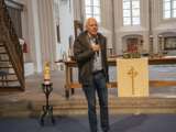 Man spreekt in microfoon in de kerk.