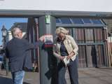 Man en vrouw staan bij citatenbord met QR-code op kerkplein in Appingedam.